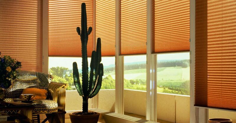 Mehrere Plissees schützen einen Wohnraum vor Sonneneinstrahlung