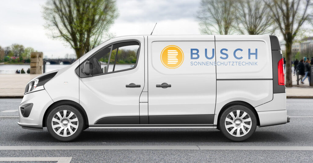 Weißer Lieferwagen mit dem Logo „BUSCH SONNENSCHUTZTECHNIK“ an der Seite, geparkt auf einer Straße. Im Hintergrund sind Bäume und ein Fluss unter einem bewölkten Himmel zu sehen.