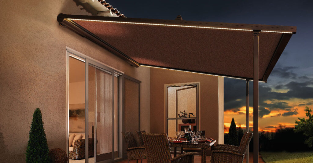 Braune Pergolamarkise mit integrierter Beleuchtung über einem Essbereich im Freien.