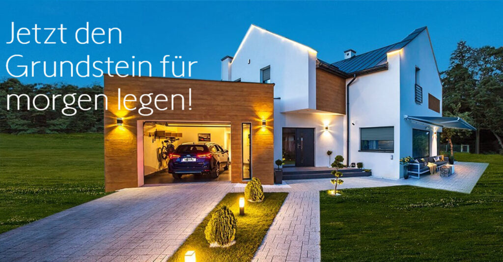 Modernes zweistöckiges Haus mit beleuchteter Einfahrt, offener Garage mit Auto und Außenbeleuchtung in der Dämmerung. Der deutsche Text links lautet: „Jetzt den Grundstein für morgen legen!“.