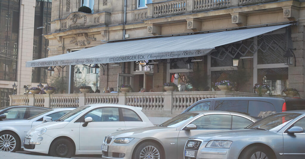 Graue Markise über dem Eingang des Steigenberger Eck Restaurants mit Schriftzug.